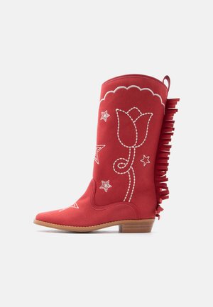 Botte de cowboy en daim rouge avec des coutures blanches florales et étoilées, bord supérieur festonné, franges latérales et talon en bois bas.