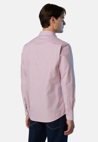 Camisa de manga larga a rayas rojas y blancas con cuello abotonado, dobladillo curvado y puños con un solo botón. Tejido de mezcla de algodón, con una textura sutil.