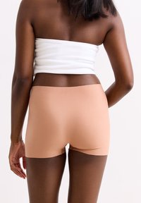 Naadloze, rekbare katoenen boyshorts in een nude tint, met een soepele tailleband en delicate beenopeningen voor een gestroomlijnde look.