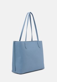 Ljusblå toteväska med en slät, strukturdesign, som har två långa handtag och ingen synlig metall eller mönster.