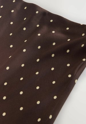 Brauner Stoff mit glatter Textur, versehen mit gleichmäßig verteilten cremefarbenen Polka-Dots, die ein verspieltes Muster über die Oberfläche schaffen.