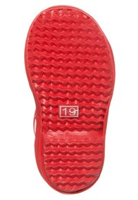 Semelle en caoutchouc rouge avec un motif zigzag texturé. Présente le numéro blanc "19" dans un rectangle près du centre.