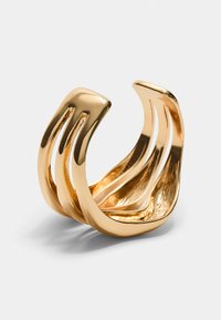 Goudkleurige open ring met een golvend ontwerp, voorzien van drie smalle verticale uitsparingen en een gladde, gepolijste textuur.