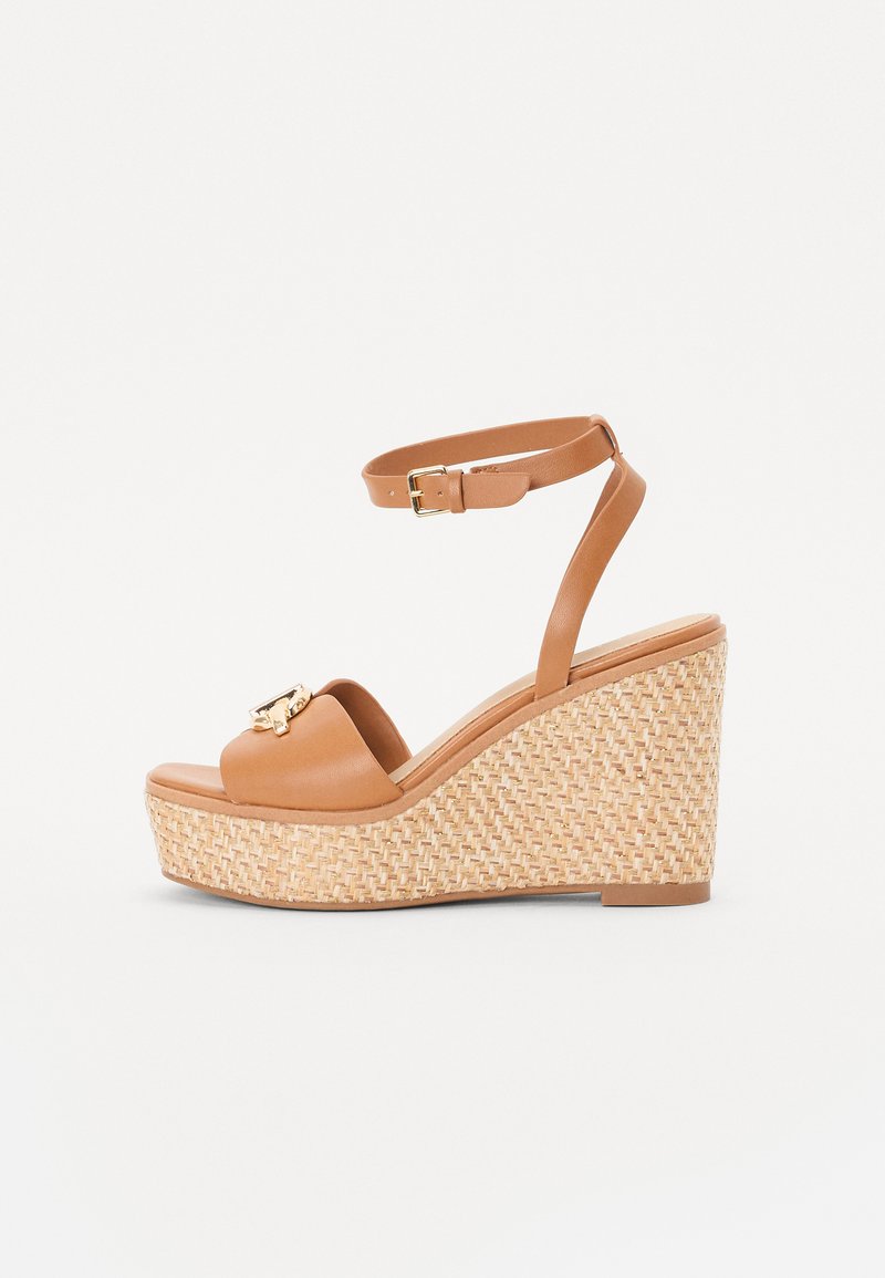 Wedge sandals with a tan leather upper, an ankle strap, and a woven, textured platform. Gold hardware accent on the front.
