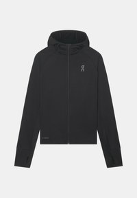 Veste noire à capuche avec fermeture éclair intégrale, manches longues et trous pour les pouces, avec un petit logo réfléchissant sur la poitrine et le bas devant.