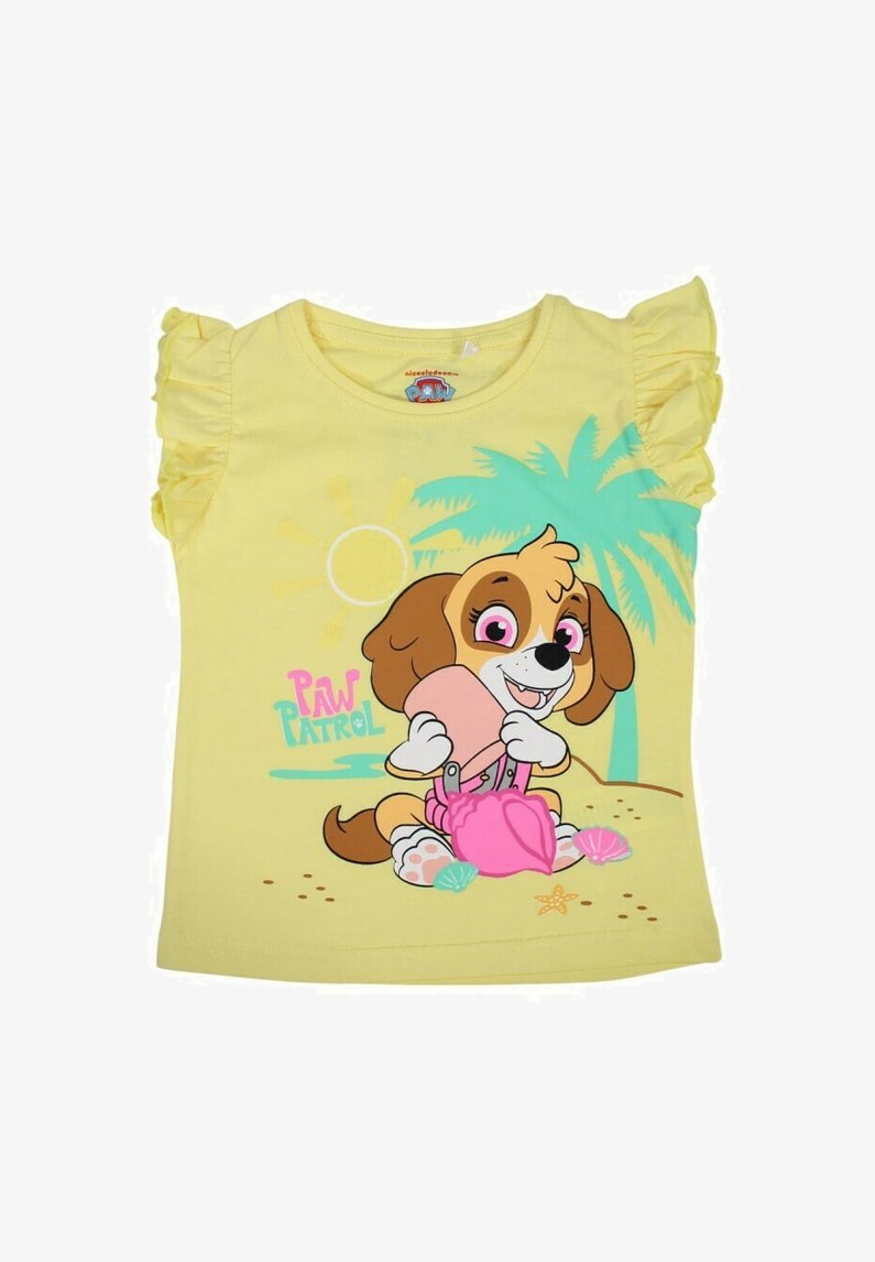 Chemise jaune à manches courtes avec des manches volantes, présentant un chien de dessin animé tenant une pelle rose sur fond de plage avec des palmiers.
