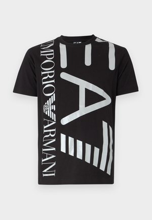 Must musta t-särk, millel on suur hõbedane trükitud tekst ja graafikadisain. Ümar kaelus ja lühikesed varrukad sujuva tekstuuriga.