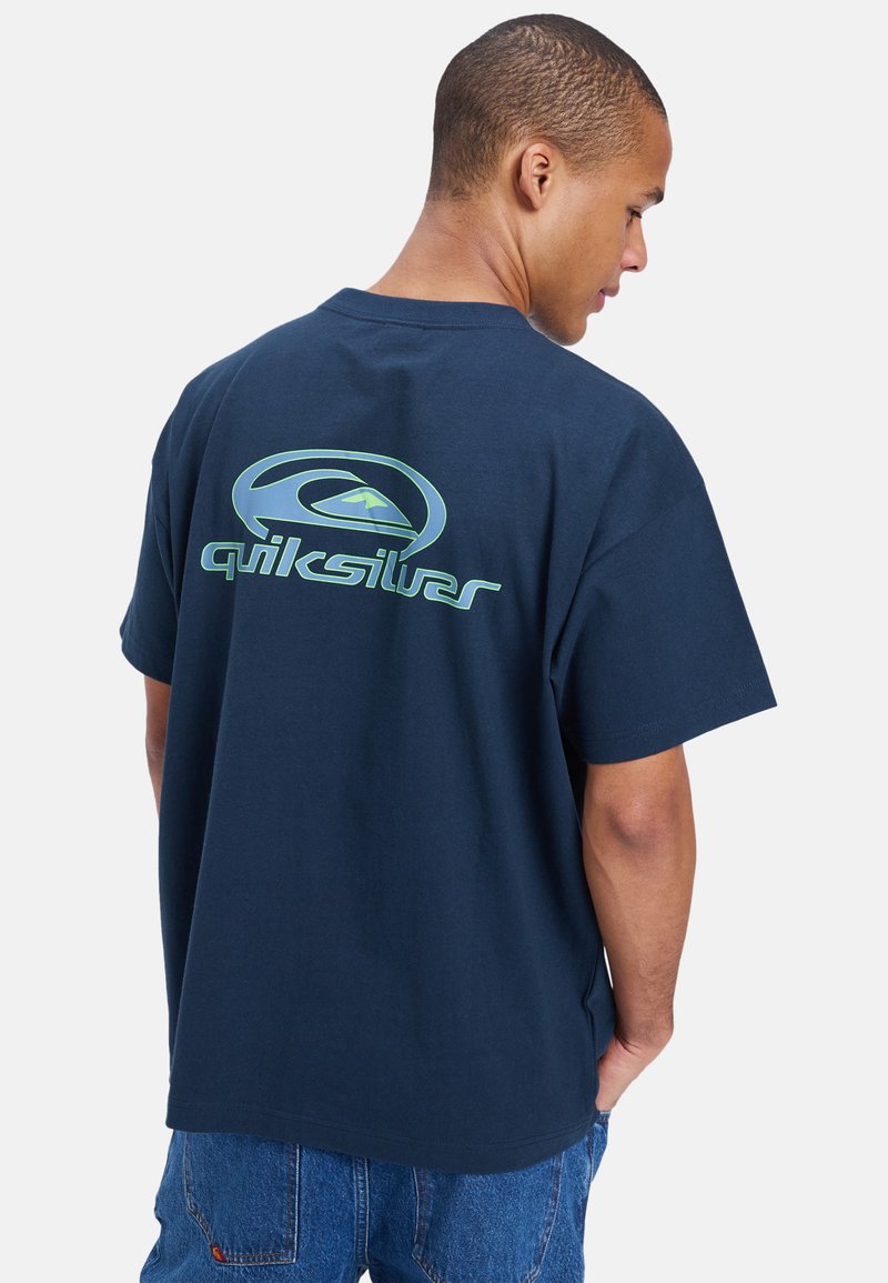 Marineblå bomull t-skjorte med en stor grønn Quiksilver-logo på ryggen, korte ermer og en avslappet passform.