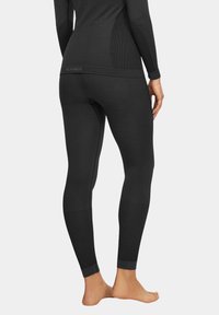 Czarne legginsy termiczne o dopasowanym kroju, z ryflowanym wykończeniem w okolicy kostki i dolnej części nogi, wykonane z elastycznego, oddychającego materiału.