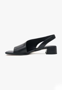 Zwarte leren slingback sandaal met een open teendesign, lage chunky hak, gladde textuur en een minimalistische esthetiek.