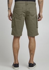 Olijfgroene cargoshorts met een losse pasvorm, meerdere zakken en een omgeslagen zoom, gemaakt van duurzaam stof met een gestructureerde afwerking.