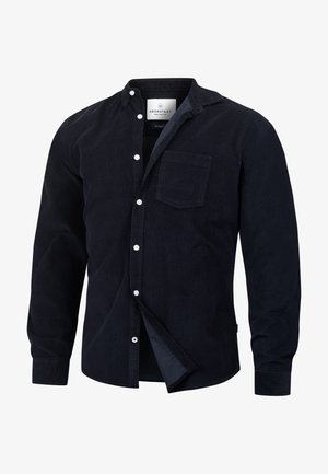 Mørk marineblå kordfløyels skjorte med knappestolpe og brystlomme, hvite knapper og en myk tekstur. Har klassisk krage og lange ermer.