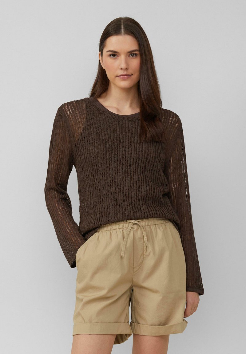 Pull en tricot brun à manches longues avec un motif texturé, associé à un short beige clair avec cordon de serrage, revers aux poignets et poches latérales.