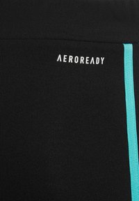 Pantalones cortos deportivos negros con una textura ribeteada, con una franja turquesa a lo largo del lado y el logo "AEROREADY" en blanco.
