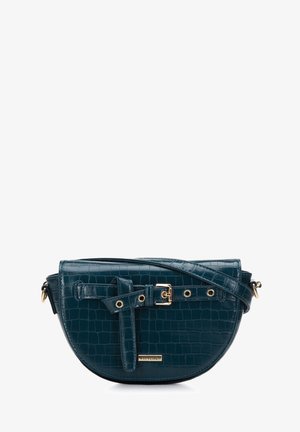 Teal faux-crocodile leather crossbody bag with a curved shape, gold hardware, a buckle detail on the front, and an adjustable strap.