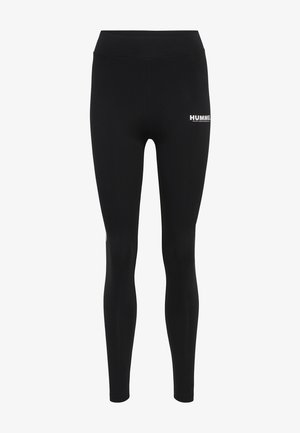 Leggings noirs en tissu extensible, avec une taille haute et un logo blanc sur la partie supérieure de la cuisse. Texture lisse dans l'ensemble.
