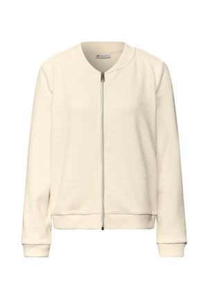 Kremowa kurtka typu bomber z teksturowanym wzorem, zamkiem błyskawicznym, ściągaczami na rękawach i okrągłym kołnierzem. Lekka tkanina. Casualowy design.