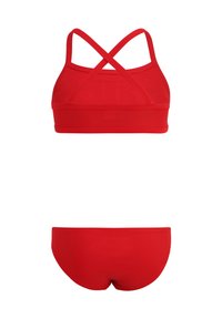 Röd tvådelad baddräkt som har en crop top med korsade band och en slät, sömlös underdel. Tillverkad av elastiskt och lättviktigt tyg.