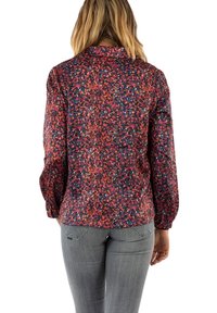 Multicolored blouse with a patterned texture, featuring long sleeves and a collar, paired with gray jeans. Back view shown.