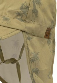 Khaki-Kappe mit Tiermuster, das Giraffen und Palmen zeigt. Weicher Stoff, verstellbarer Kinnriemen und Leder-Brand-Patch an der Seite.