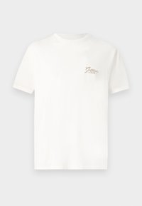 Camiseta blanca de algodón con mangas cortas. Presenta un pequeño texto de logo en beige en la parte izquierda del pecho. Cuello redondo simple y clásico.
