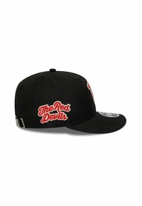 Casquette de baseball noire avec "The Red Devils" brodé en rouge et blanc sur le côté, sangle ajustable à l'arrière, visière plate.