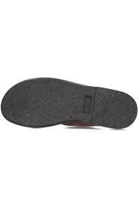 Zwarte rubberen schoenzool met een gestructureerd grip patroon en gladde randen, featuring een centrale logo-afdruk en zonder zichtbare slijtage of krassen.