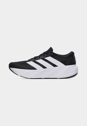 Zapatilla de correr Adidas en blanco y negro con entresuela blanca, suela exterior negra y tres grandes rayas blancas en el lateral.