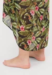 Blomstrete maxi-skjørt med mørk bakgrunn, med store grønne blader, rosa blomster og oransje detaljer. Lett materiale med en flytende design.