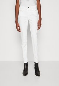 Jeans bianchi aderenti con davanti piatto, cinque tasche e chiusura con un unico bottone. Il materiale sembra liscio con una leggera lucentezza.