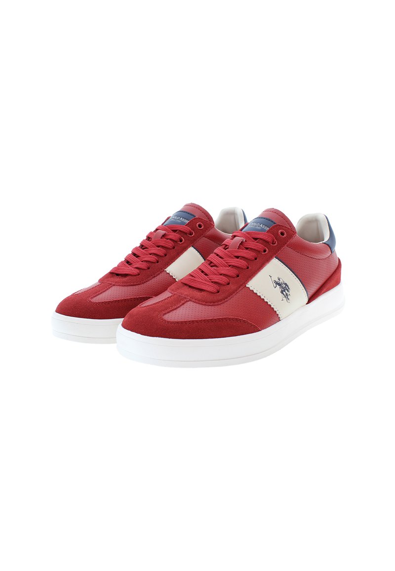 Une paire de baskets basses rouges et blanches avec des lacets, des détails perforés et un logo de joueur de polo noir sur le côté, sur un fond blanc.