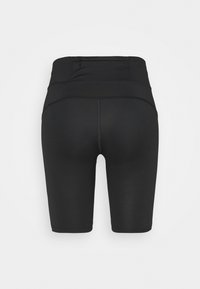 Shorts de sport noirs avec une taille haute, dotés d'une petite poche zippée à l'arrière et d'une texture de tissu lisse et élégante.