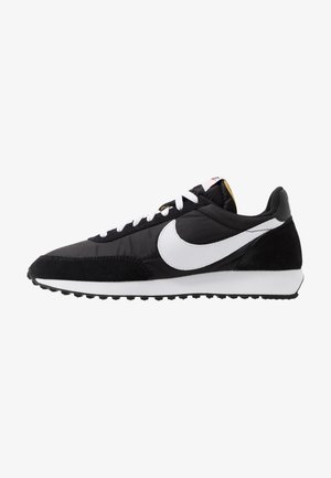 Czarno-biały but do biegania Nike z białym logo Swoosh, białymi sznurówkami i teksturowaną podeszwą zapewniającą przyczepność, widoczny z lewej strony.