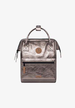 Metallisch bronzefarbenen Rucksack mit doppelten oberen Griffen, vorderem Reißverschlussfach, Leder-Logo-Patch und verstärkten Nähten. Glatte Textur, strukturierte Form.