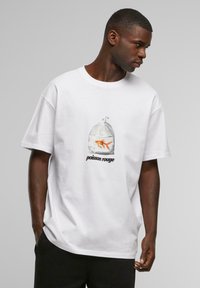Hvid bomulds-t-shirt med et grafik af en guldfisk i en gennemsigtig pose, med sort tekst "poisson rouge" under billedet.