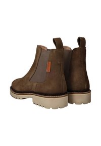 Bruine suède chelsea boots met elastische zijkanten, trekhaakjes en beige rubberen zolen met een gegroefd profiel.