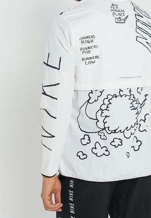 Veste blanche avec un motif graphique noir de nuage, texte "RUN TO A MAGICAL PLACE" et "RUNNERS HIGH RUNNERS MID RUNNERS LOW" au dos.