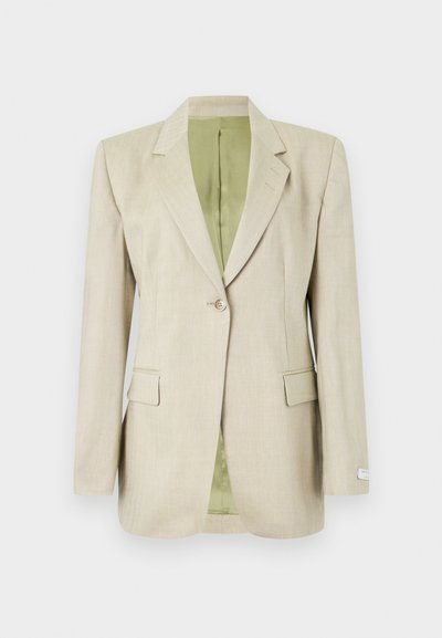 Μπεζ σακάκι με ένα κουμπί, γιακά με χαραγή, τσέπες με καπάκι και εσωτερική επένδυση σε ανοιχτό πράσινο χρώμα, παρουσιάζεται σε λευκό φόντο.