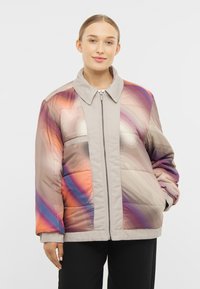 Padded jacket w wielokolorowym abstrakcyjnym wzorem w odcieniach pomarańczowego, purpurowego i beżowego. Posiada zamek błyskawiczny z przodu oraz kołnierz.