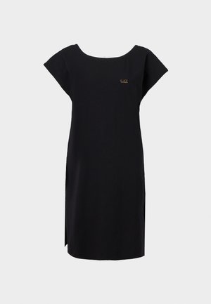 Μαύρο φόρεμα μήκους μέχρι το γόνατο με κοντά μανίκια, στρογγυλή λαιμόκοψη, μικρό χρυσό λογότυπο στο στήθος και σκίσιμο στο πλάι πάνω σε ανοιχτό γκρι φόντο.