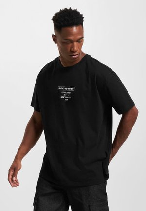 Black short-sleeve t-shirt, cotton material, crew neckline. Front features white text logo: "ROCA&WEAR ESTABLISHED 1999 NEW YORK CITY USA."