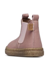 Růžová kožená kotníková bota s elastickými bočními panely a texturovanou hnědou podrážkou. Na zadní straně se nachází malý logotyp pro branding.