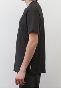 Sort bomulds T-shirt med korte ærmer, rund hals og lige snit. Har et lille stofmærke på siden.
