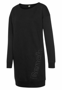 Schwarzes Sweatkleid mit langen Ärmeln, rundem Ausschnitt und seitlichem Logo-Detail. Aus weichem Stoff gefertigt, mit lockerer Passform und gerippten Bündchen.