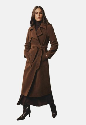 Manteau trench en daim marron avec une taille ceinturée, de grands revers crantés, des boutons double boutonnage et une silhouette à longueur complète.
