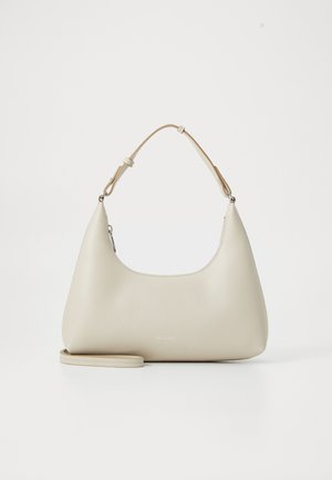 Beige leather shoulder bag with a curved shape, adjustable strap, and a smooth texture. Features minimal branding on the front.