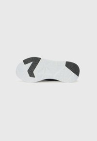 Semelle extérieure de sneaker noire avec une surface en caoutchouc blanc texturé ; présente un accent noir distinctif en forme de "7" et un motif géométrique.