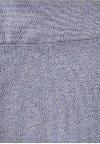 Hellviolettes, gestricktes Material mit einer glatten Textur, das ein geripptes Muster und gleichmäßige Nähte aufweist.