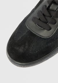 Mustad mustad, millel on segu sametist ja tekstureeritud nahast. Ümar varvas, lamedad mustad lipsud ja kummist tallad, millel on peenet joonistust.