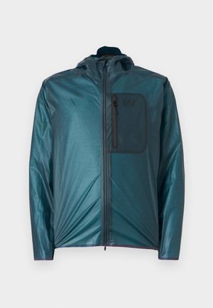 Casaco leve em verde-água com capuz, fecho frontal e um bolso no peito; textura suave e design casual. Apresenta o logo EA7 no bolso.